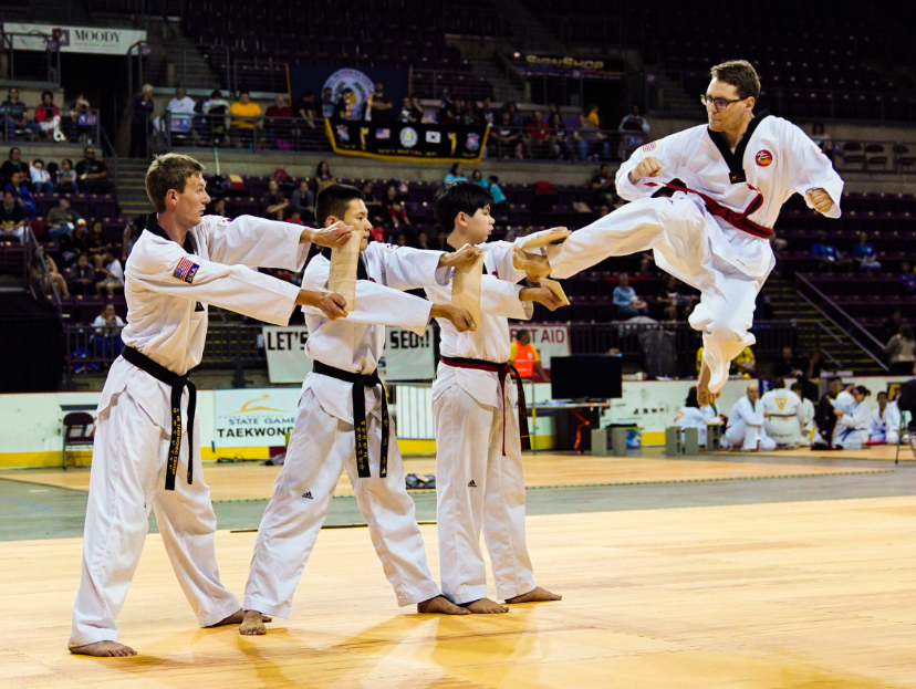 Student jumping to kick three boards in a row