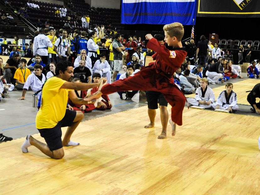 Younger student jumping to kick board