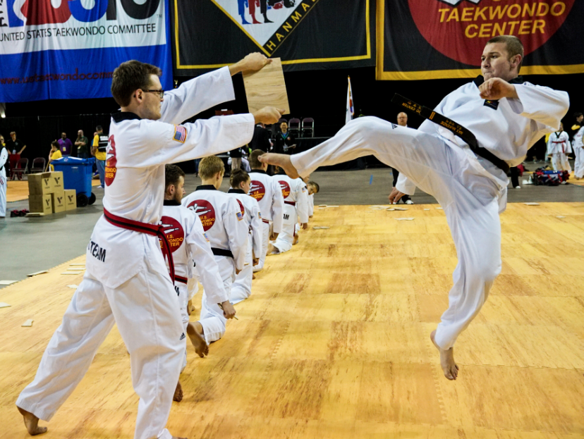 Adult student jumping to kick board